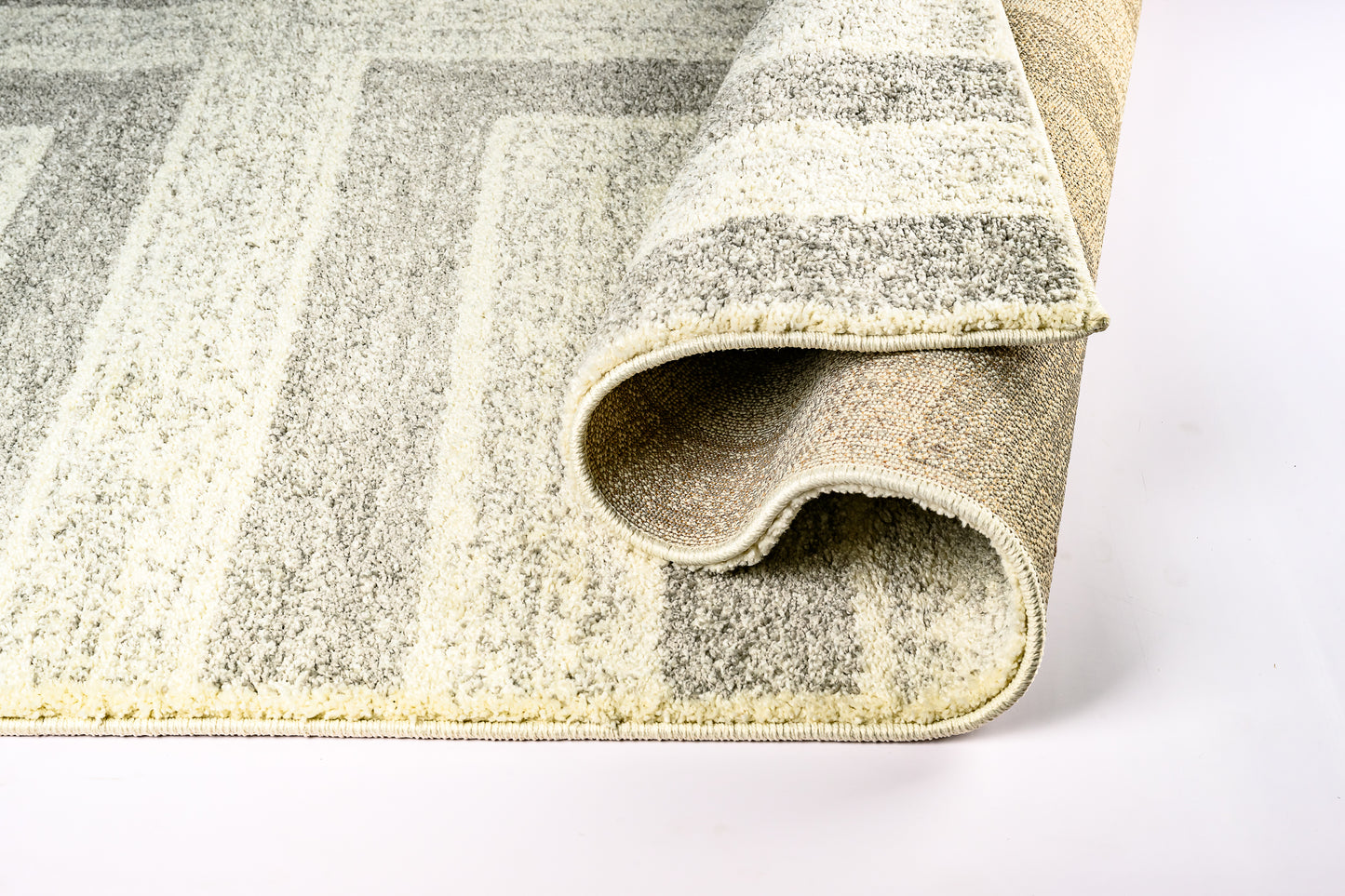 Rolled-up geometric-patterned rug on a white background