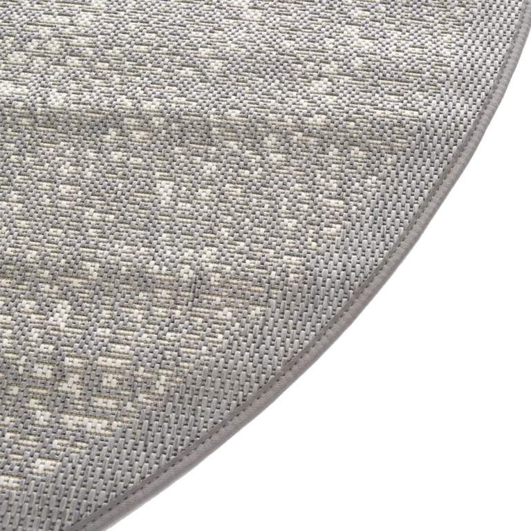 Close-up of a textured gray rug corner on a white background