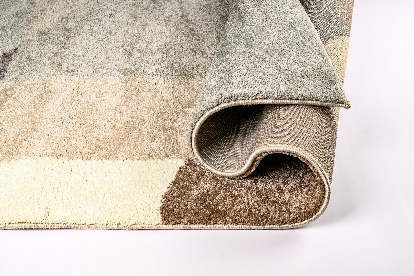 Rolled-up area rug with a geometric pattern on a white background