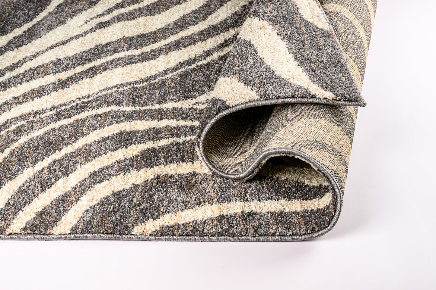 Roll of patterned rug with gray and beige stripes on a white background