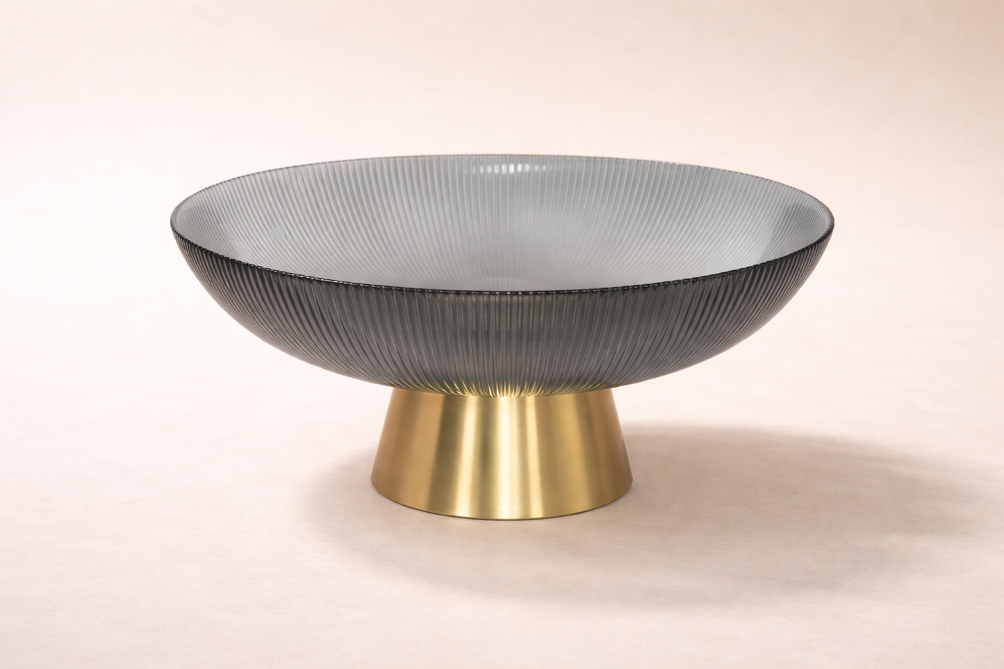 Decorative bowl with textured surface and brass base on a light background