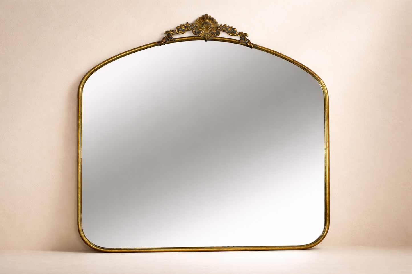 Decorative wall mirror with gold frame on a beige background
