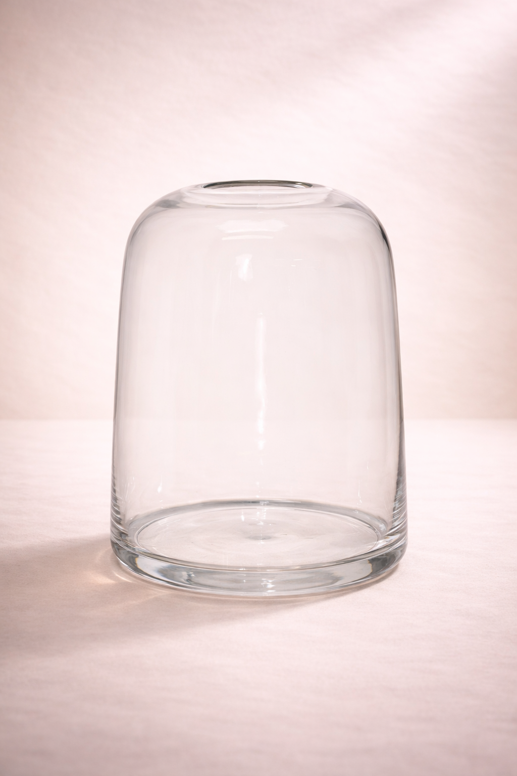 Clear glass vase on a light pink background