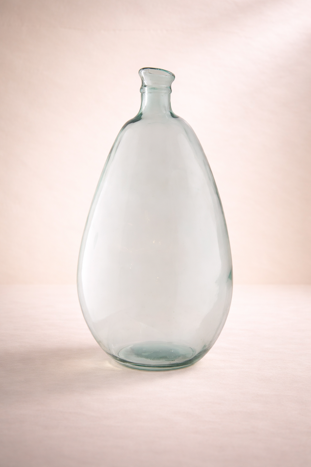 Clear glass bottle on a gradient pink background