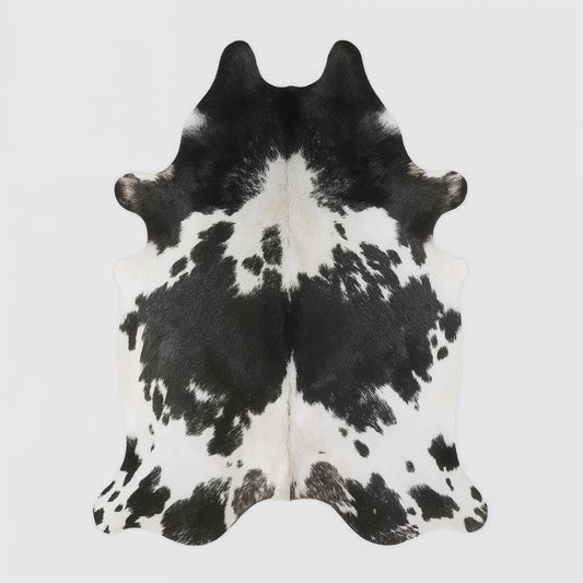 Black and white cowhide rug on a light gray background