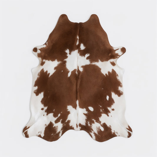 Brown and white cowhide rug on a light gray background