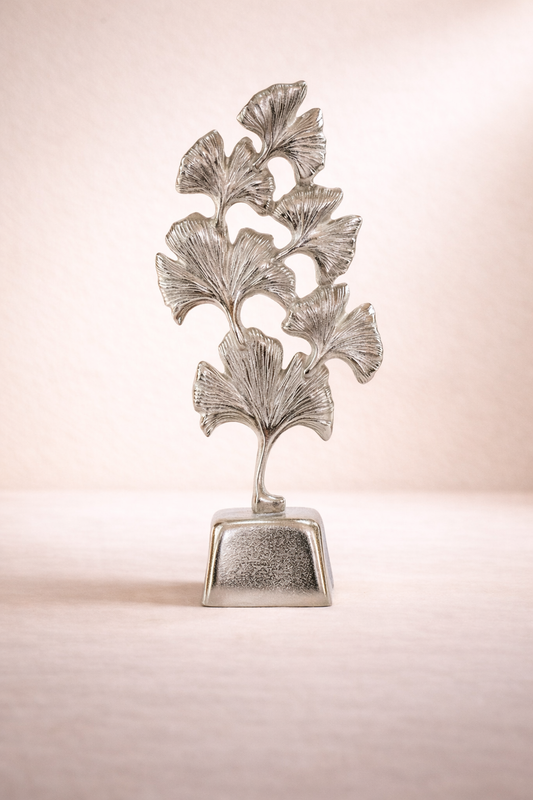 Decorative silver leaf sculpture on a beige background