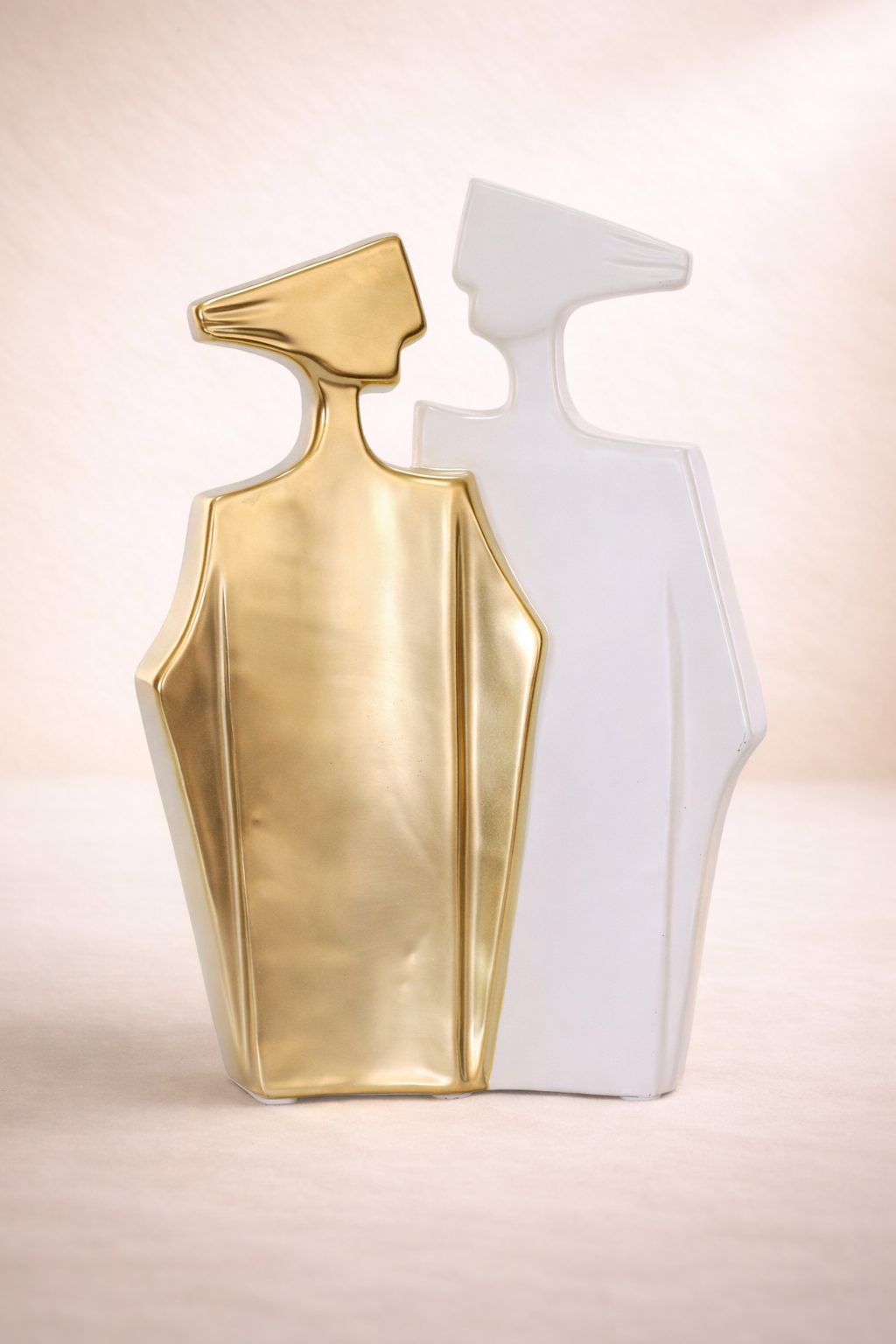 Gold and white geometric sculpture on a beige background