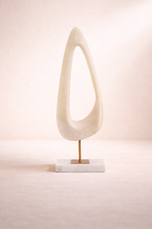 Abstract sculpture on a stand against a soft pink background