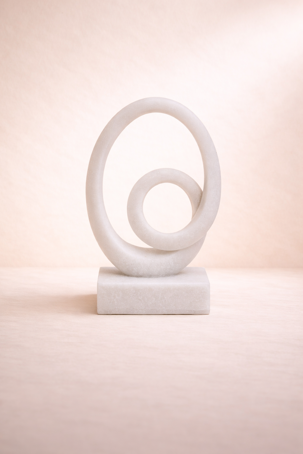 Abstract sculpture with spiral design on a light pink background