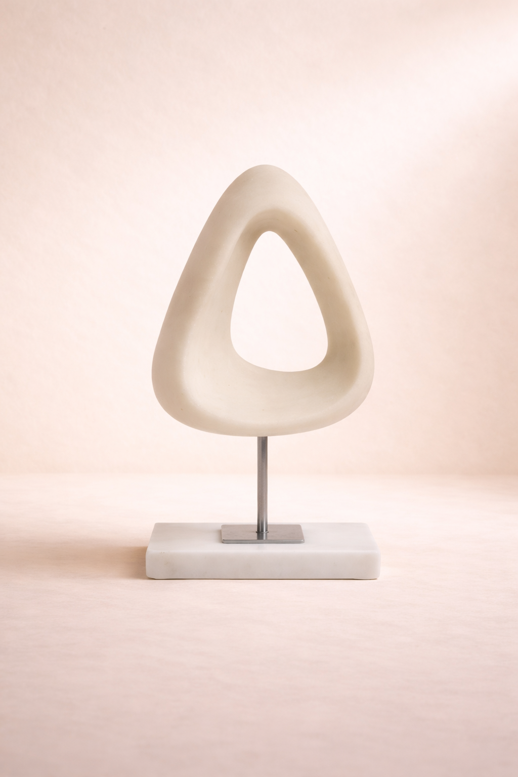 Modern table lamp with a unique white design on a soft pink background