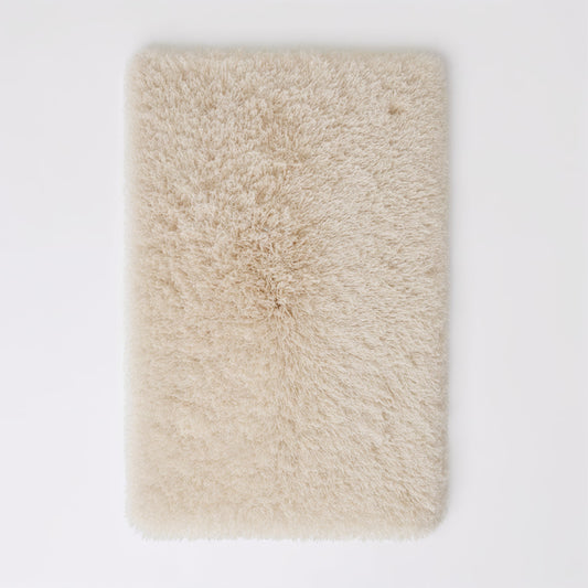 Beige fluffy rug on a white background