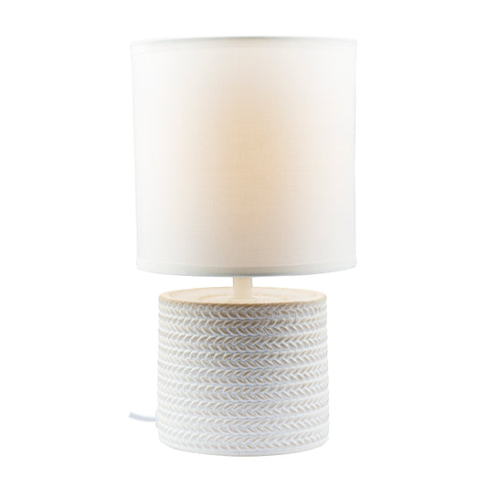Table lamp with white woven base and white shade on a white background